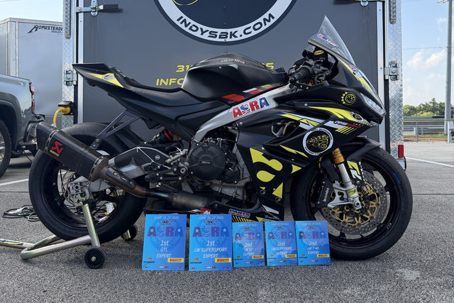 The Indy Superbikes Aprilia RS660 race bike parked in front of the shop trailer with five ASRA podium plaques from the June 2026 round lined up in front of it